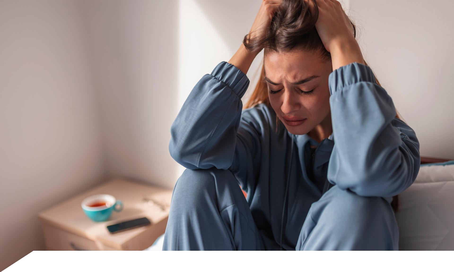 Woman sitting on bed frustrated